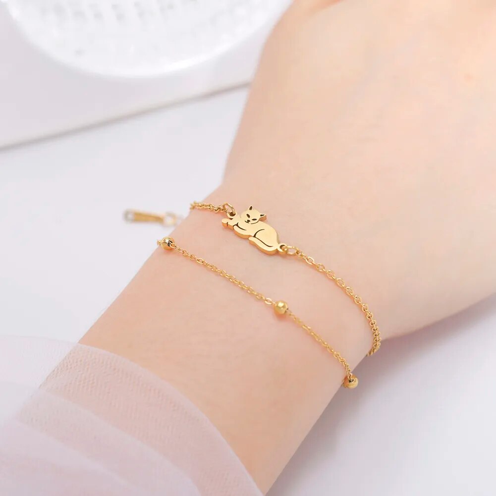 Vrouw draagt dubbele armband goudkleurig met liggende kat.