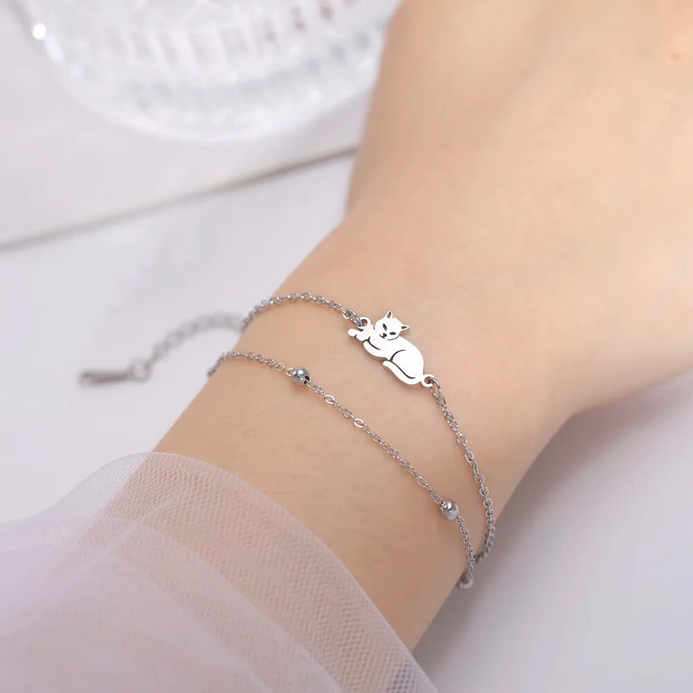 Vrouw draagt dubbele armband zilverkleurig "Liggende kat". Stainless steel met 5 cm verlengstuk.