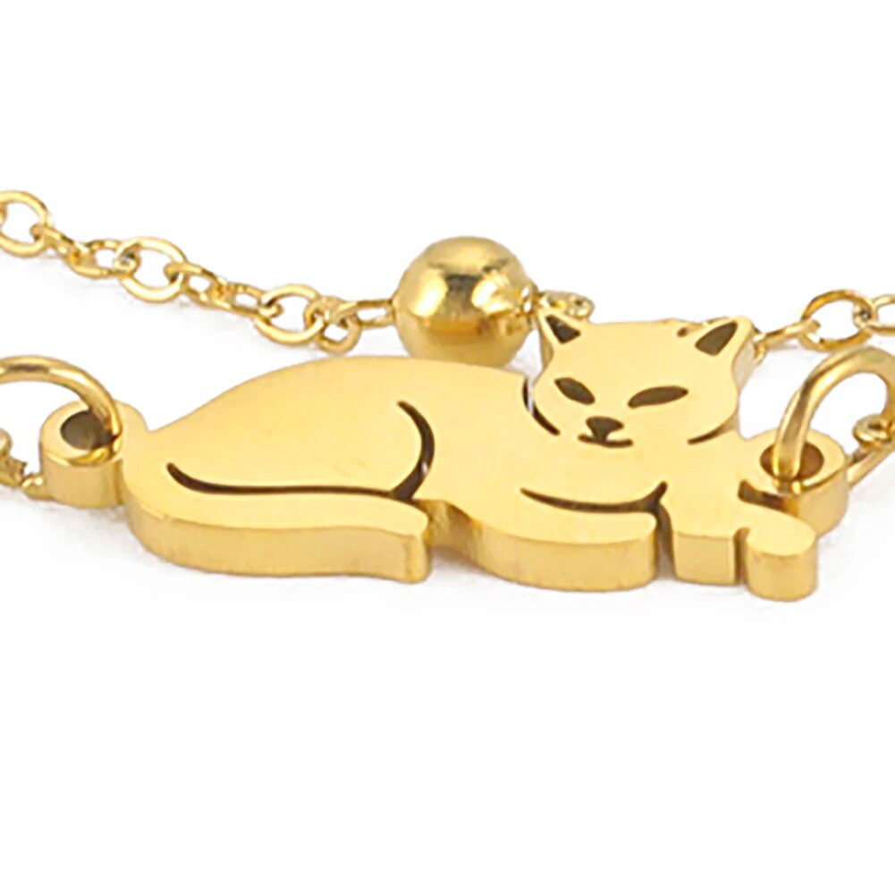 Dubbele armband goudkleurig met liggende kat en balletjes.