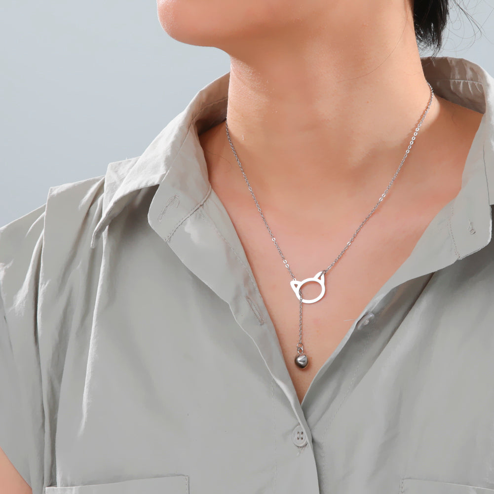 Model draagt ketting stainless steel zilver met kattenkop en zirkonia speelballetje er door heen.