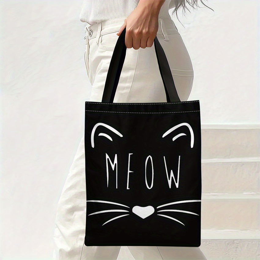 Model draagt zwarte tote bag met witte kattensnoet en MEOW tekst