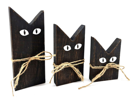 Houten katten set 3 stuks Black Wash. Minimalistisch ontwerp met gespitste oren, witte geschilderde ogen en een juten touwtje om hun nek